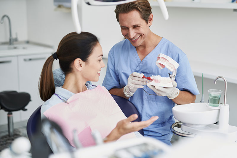 male hygienist shows to to brush teeth
